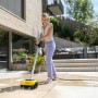 Frau reinigt Terrasse mit Kärcher PCL 6 Flächenreiniger. Elektrischer Terrassenreiniger in Gelb und Schwarz.