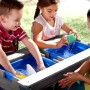 Kinder spielen am grauen Axi Sand- und Wasser-Picknicktisch Nick mit blauem Wasser.
