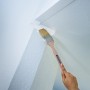 LUX Eckenpinsel 75 mm im Einsatz: Streichen einer Ecke mit weißer Farbe. Pinsel mit Holzgriff.