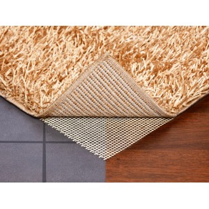 Teppichunterlage 160x220 cm unter beigem Teppich auf Fliesen und Holzboden.