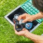 Mann setzt 9V Batterie in Gardena Bewässerungssteuerung Steuerteil Bluetooth im Garten.