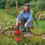 Einhell GC-DP 6935 LL Schmutzwasserpumpe im Einsatz am Gartenteich. Elektro-Pumpe mit rotem Gehäuse.