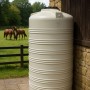 Großer weißer KMND 2000L Trinkwasser Wassertank aus PE mit Rippen, auf Terrasse im Garten. Für Regenwasser.