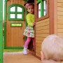 Axi Tom Spielhaus aus Holz mit roter Rutsche, braun-grün, mit spielenden Kindern.