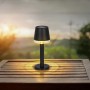 Globo LED Solarleuchte, schwarz matt, Ø 8cm, auf Holztisch mit Landschaft im Hintergrund.