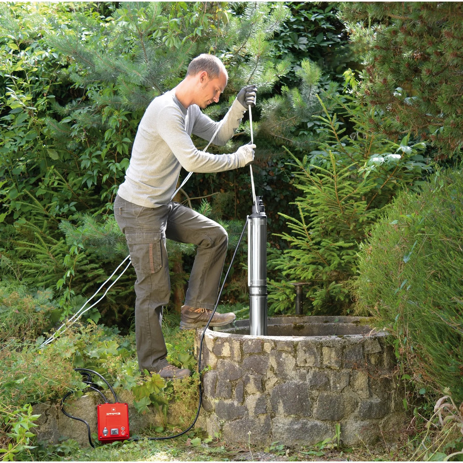 Einhell Tiefbrunnenpumpe GC-DW 1300 N im Einsatz an einem Brunnen, bedient von einer Person.