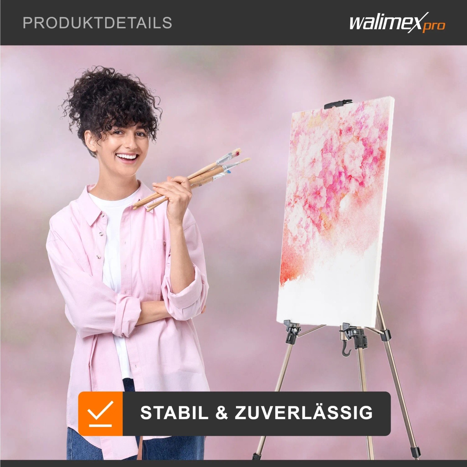 Walimex Pro Aluminium Feldstaffelei Stativ mit Leinwand und pinkem Gemälde, daneben lachende Frau mit Pinseln.