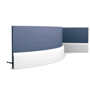 Flexible, weiße ORAC DECOR Sockelleiste SX183F AXXENT CASCADE (2m) an blauer Wand.