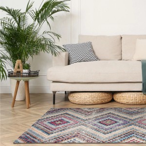 Art Universe Teppich Milano Sandy Blue mit geometrischem Rautenmuster in Blau- und Naturtönen im Wohnzimmer.
