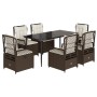 7-teilige Garten-Essgruppe aus braunem Rattan mit Tisch und Sesseln mit cremefarbenen Kissen.