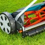 Gardena Comfort Spindelmäher 400 C auf Rasen, Detailaufnahme der Schneidwalze und Räder.