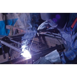 Schweißer mit LUX Stabelektrode 2,5mm x 350mm beim Schweißen von Metall.