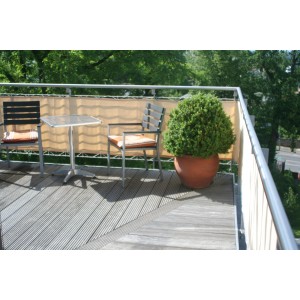 Floracord Balkonverkleidung Sisal (75x300cm) als Sichtschutz auf einem Balkon mit Möbeln und Pflanze.
