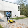 Gelbe Kärcher Kehrmaschine S6 Twin im Einsatz zum Laub kehren auf einer gepflasterten Fläche.