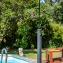 Schwarze Gre Solardusche aus Aluminium (18 l) neben Pool auf Holzdeck.