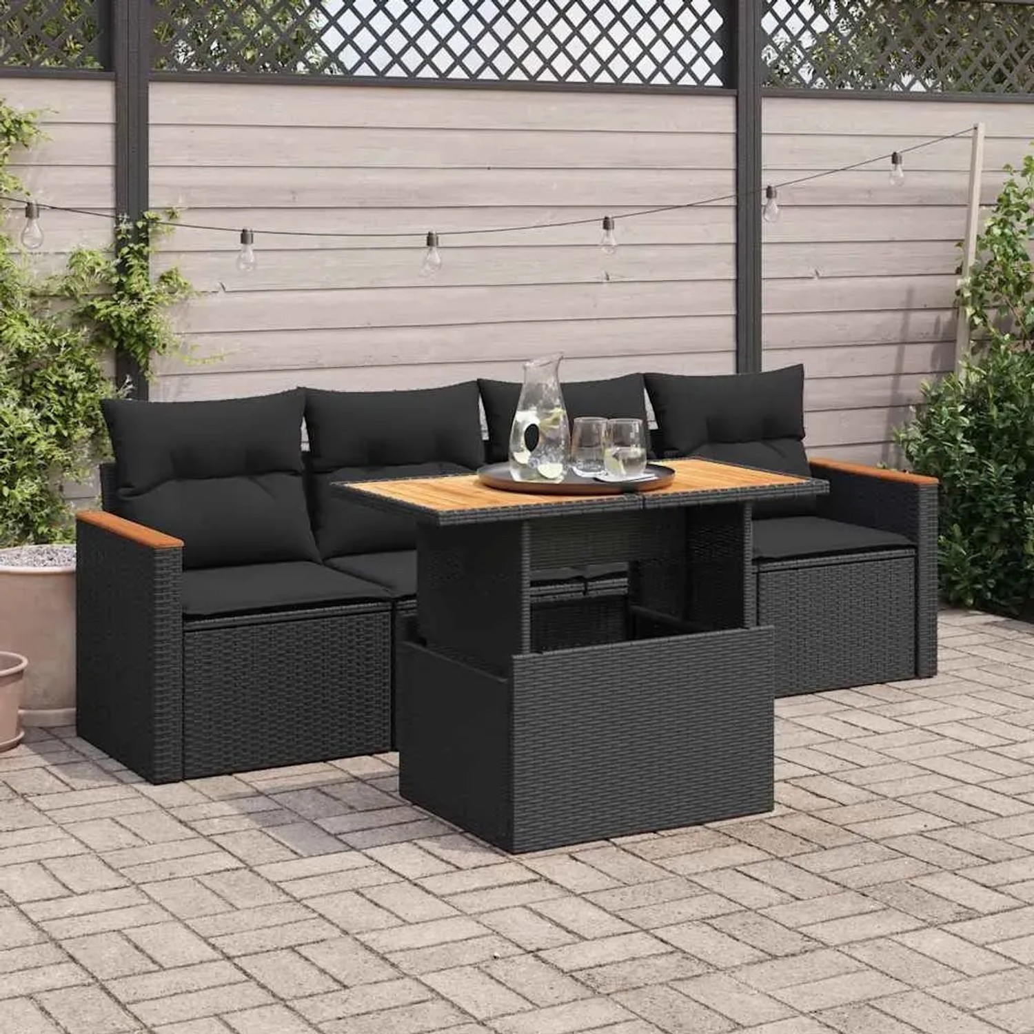 Schwarze 5-tlg. Garten-Sofagarnitur aus Poly Rattan mit Akazienholz-Tisch und Kissen.