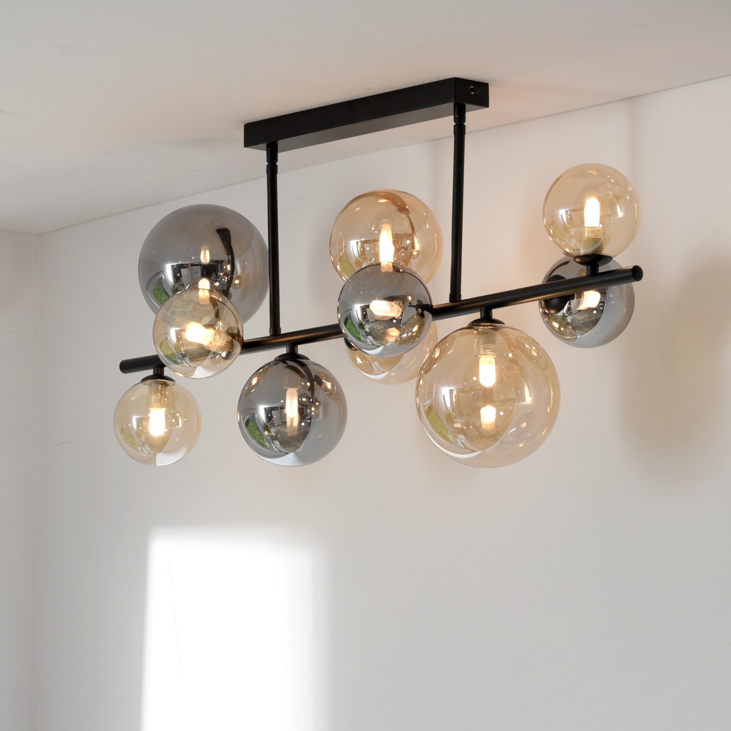 Schwarze Paul Neuhaus Deckenleuchte Popsicle mit 10 Amber- und Rauchglas-Kugeln, 85 cm breit.