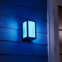 Philips Hue Impress LED-Wandleuchte, schwarz, mit farbigem Licht an Hauswand.
