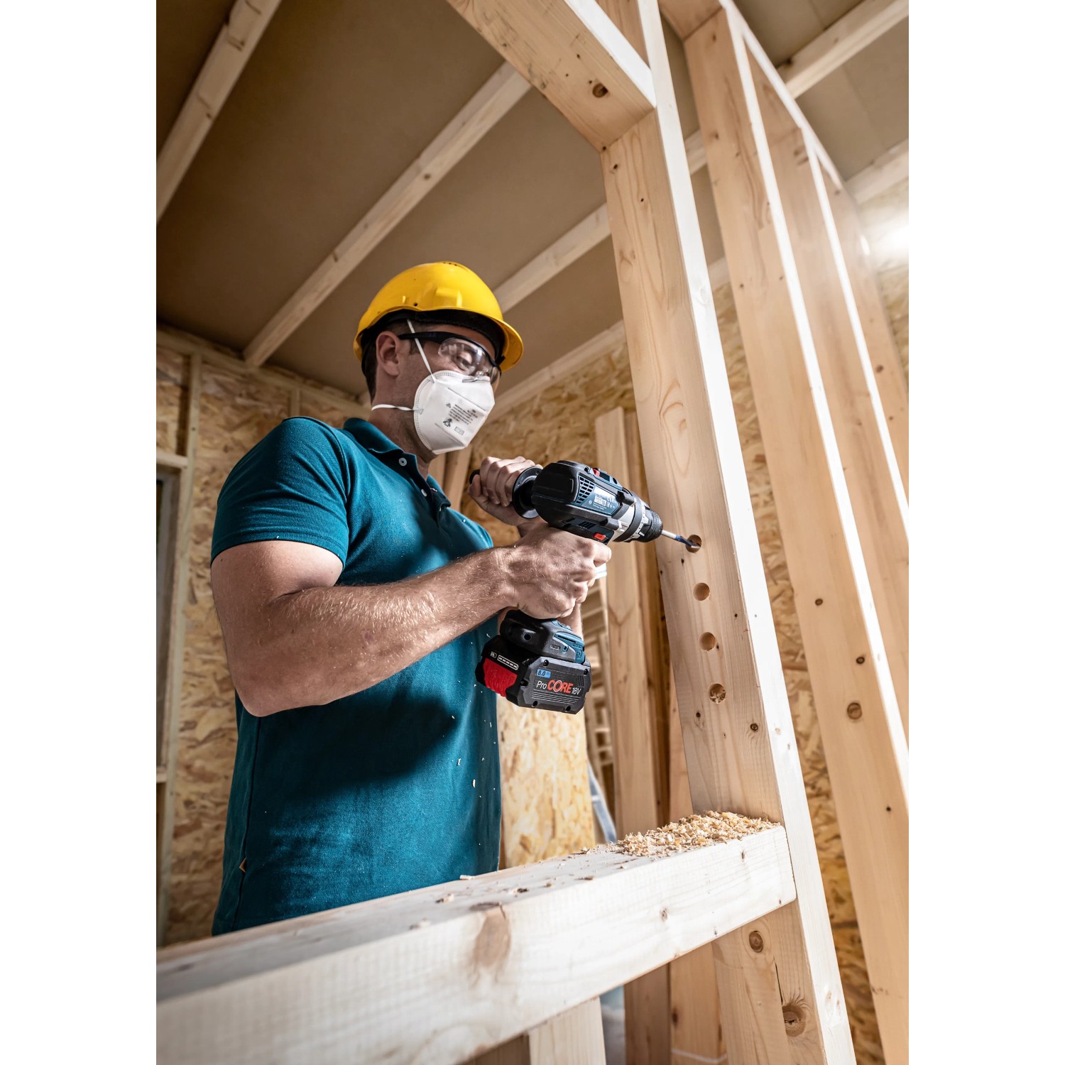 Handwerker bohrt mit Bosch Expert Flachfräsbohrer Loch in Holzkonstruktion.