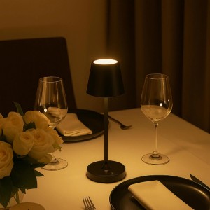 Mattschwarze Brilliant LED-Tischleuchte Elora auf Esstisch, spendet warmweißes Licht. Kabellos, dimmbar, für Ambiente.