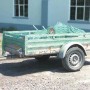 Grünes Ladenetz auf Anhänger mit Ladung, gesichert durch Westfalia Gummispanner. Perfekt für Ladungssicherung.