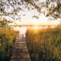 Komar Vlies Fototapete Lakeside: Holzsteg am Seeufer im Sonnenaufgang, Natur Fototapete