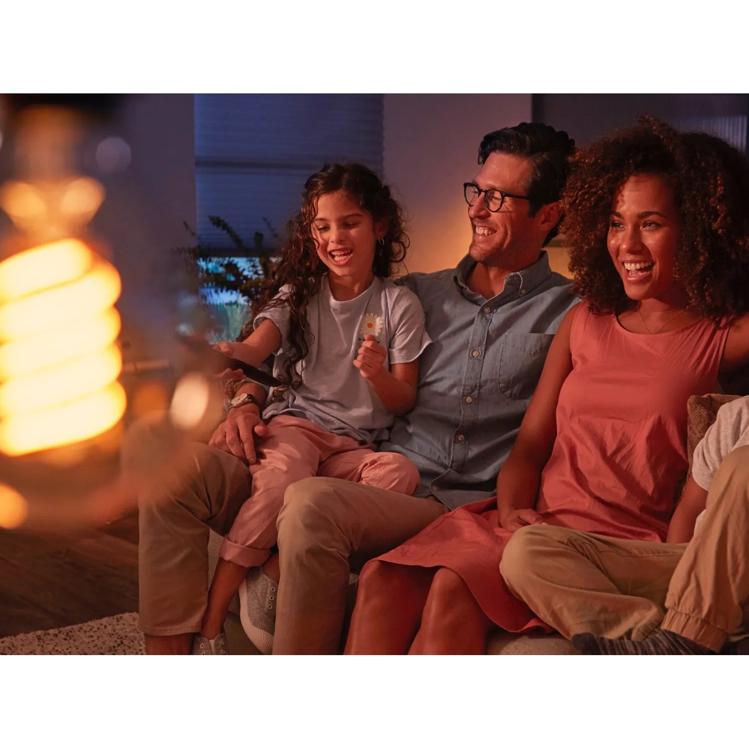 Philips Hue Filament Leuchtmittel ST72: Familie entspannt im warmen Licht der Vintage Lampe.