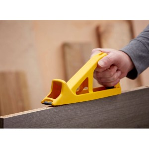 Gelber Stanley Surform Hobbyhobel 255 mm in Aktion auf Holz, ein Hobel & Beitel Werkzeug.