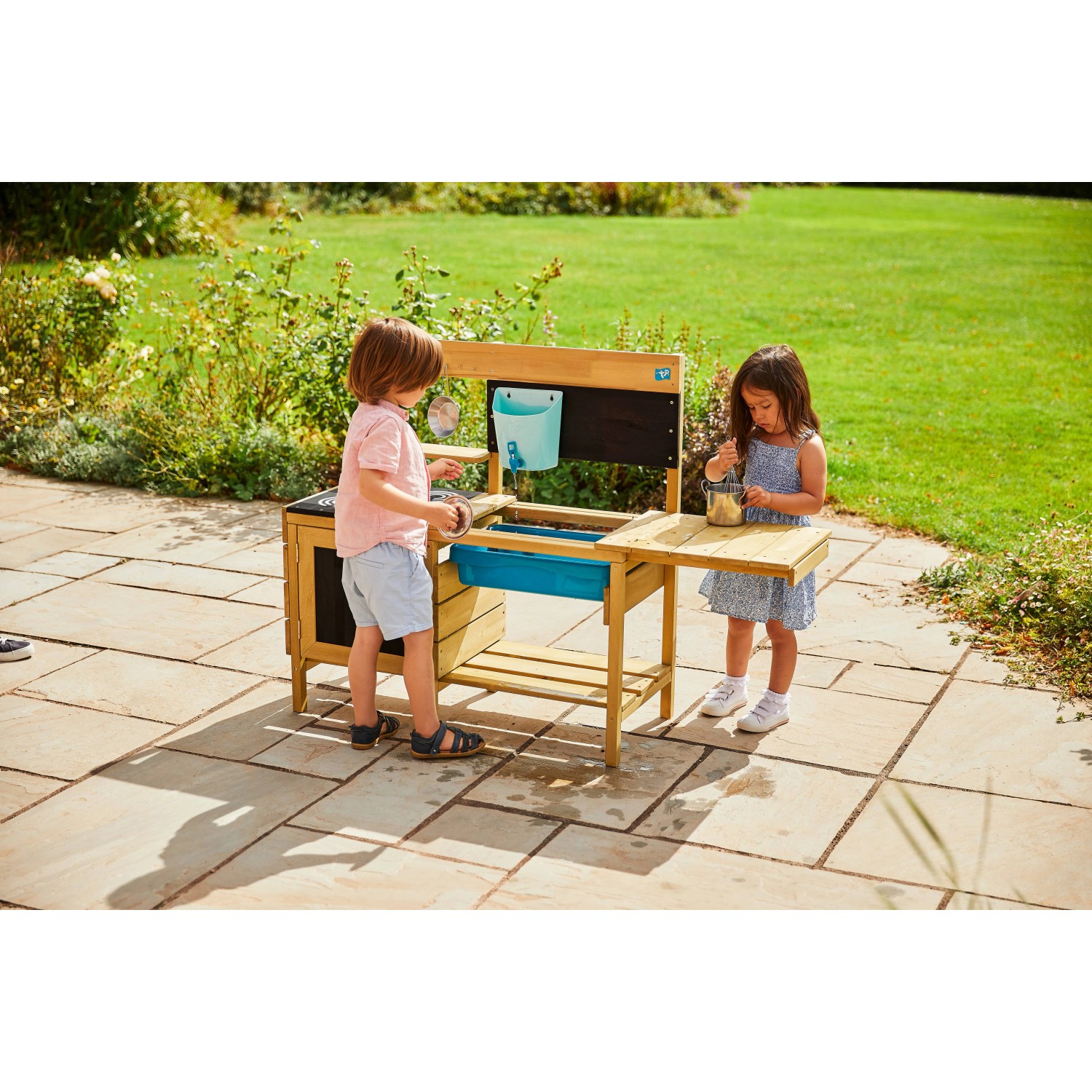 TP Toys Kinderspielküche Deluxe aus Holz mit Zubehör und zwei spielenden Kindern.