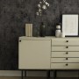 A.S. Création Vliestapete New Walls Putzstruktur Schwarz an Wand hinter Sideboard mit Deko.