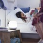 Weiße WiZ LED-Tischleuchte Hero neben Kind im Bett beim Lesen.