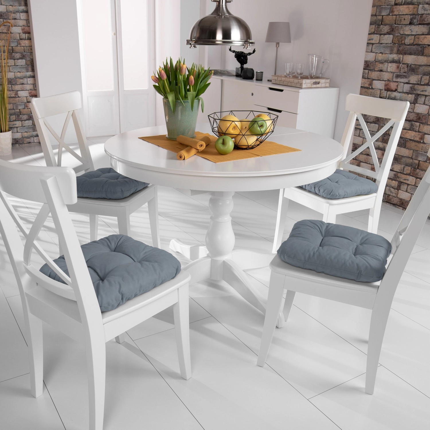 4er Set Beautissu Lisa Stuhlkissen 40x40 Grau auf weißen Stühlen am Esstisch.