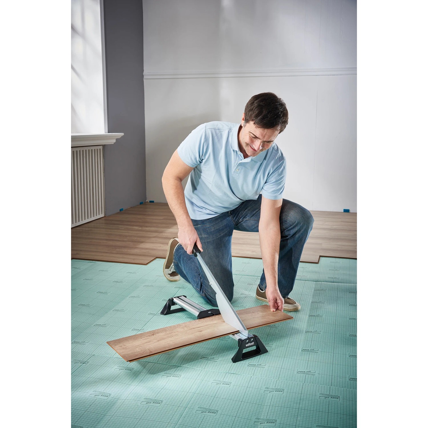 Mann schneidet Laminat mit wolfcraft Laminatschneider LC 600. Werkzeug für präzise Laminatschnitte.
