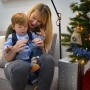 Kind öffnet blaues DIY Adventskalender-Säckchen mit Mutter. Jutesäckchen als Weihnachtsdekoration am Baum, zum Befüllen.