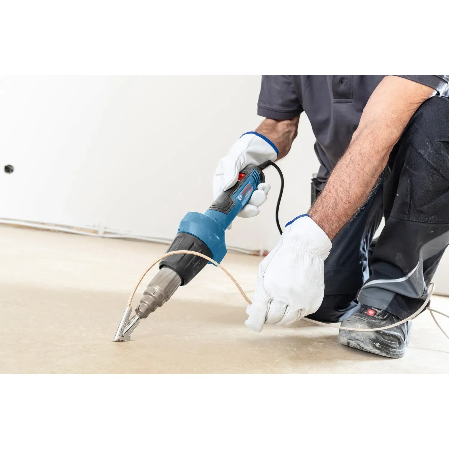Bosch Professional Heißluftgebläse GHG 20-60 im Einsatz beim Entfernen von Bodenbelag.