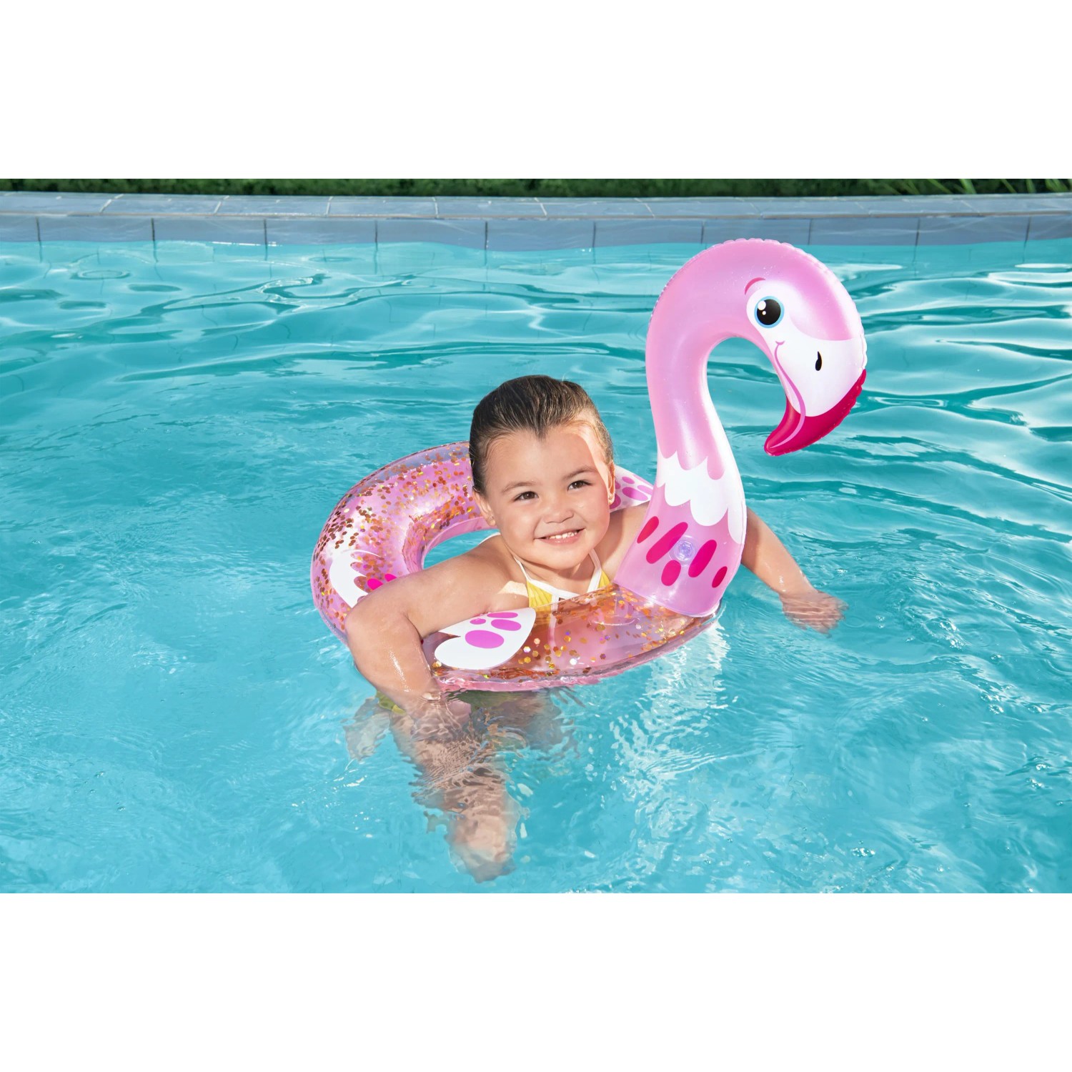Kind mit glitzerndem Bestway Schwimmring (Flamingo) im Pool.