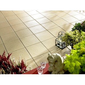 Verlegte, creme-farbene Kann Terrassenplatten Sincera 40x40 cm mit Pflanzen und Deko.