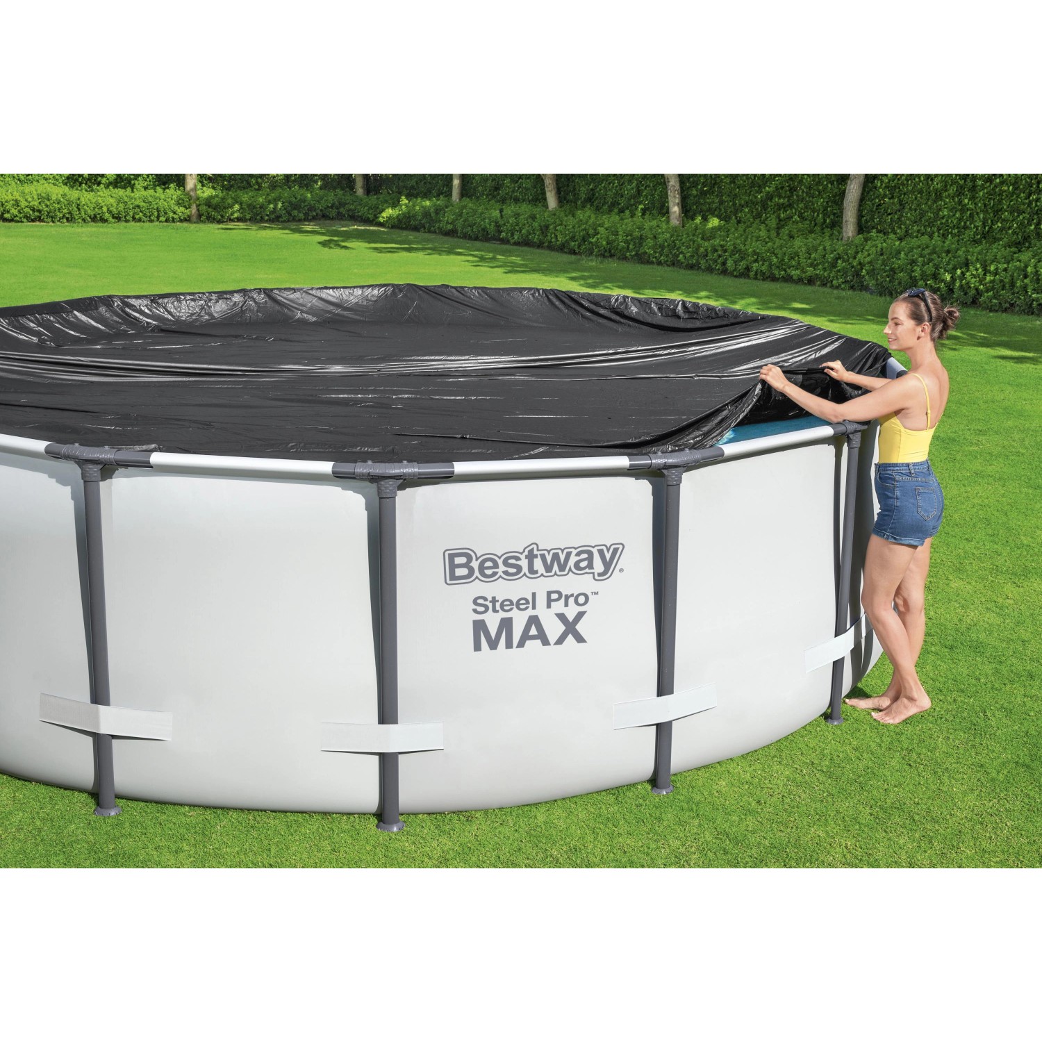 Bestway Pool Abdeckplane, Ø 305 cm, schwarz, PVC, rund. Frau befestigt die Plane an einem Pool.