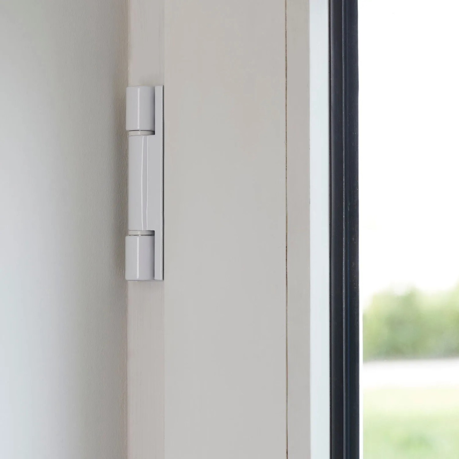 Weißes SOTECH Fensterband 95mm aus Aluminium am Fensterrahmen.