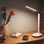 Weiße Philips LED Schreibtischleuchte Ivory mit Akku auf einem Schreibtisch.