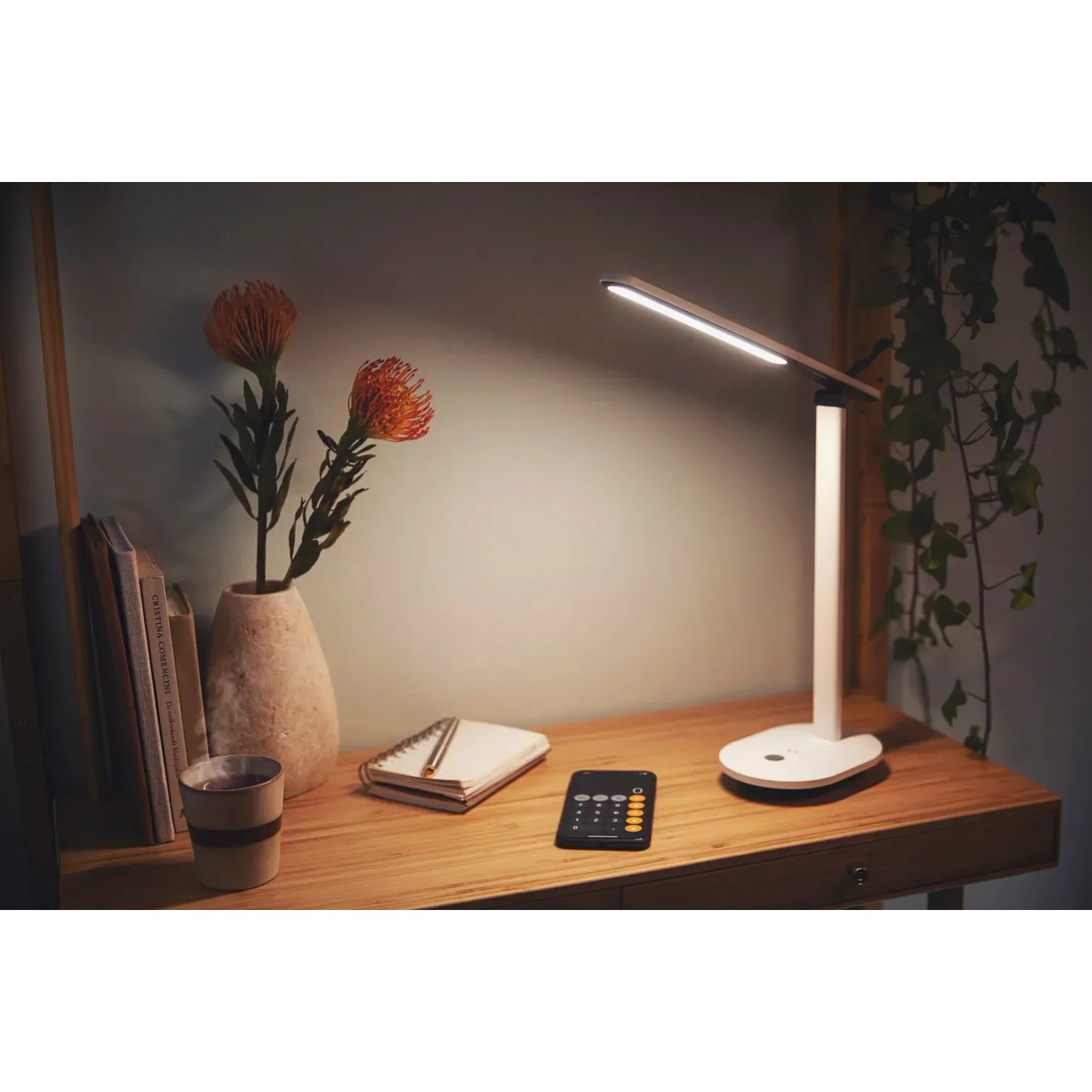 Weiße Philips LED Schreibtischleuchte Ivory mit Akku auf einem Schreibtisch.