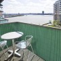 Grüner KARAT PVC Sichtschutzzaun (150x500 cm) auf Balkon mit Tisch und Stühlen.