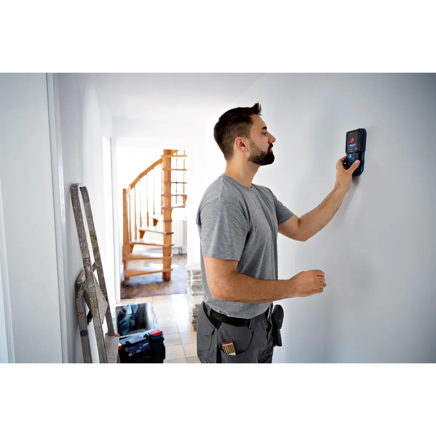 Mann benutzt Bosch Professional GMS 120-27 Ortungsgerät an Wand. Prüfwerkzeug zur Detektion.