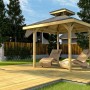 Weka Pavillon Gartenoase mit Dachaufsatz und zwei Liegen auf Holzterrasse im Garten.