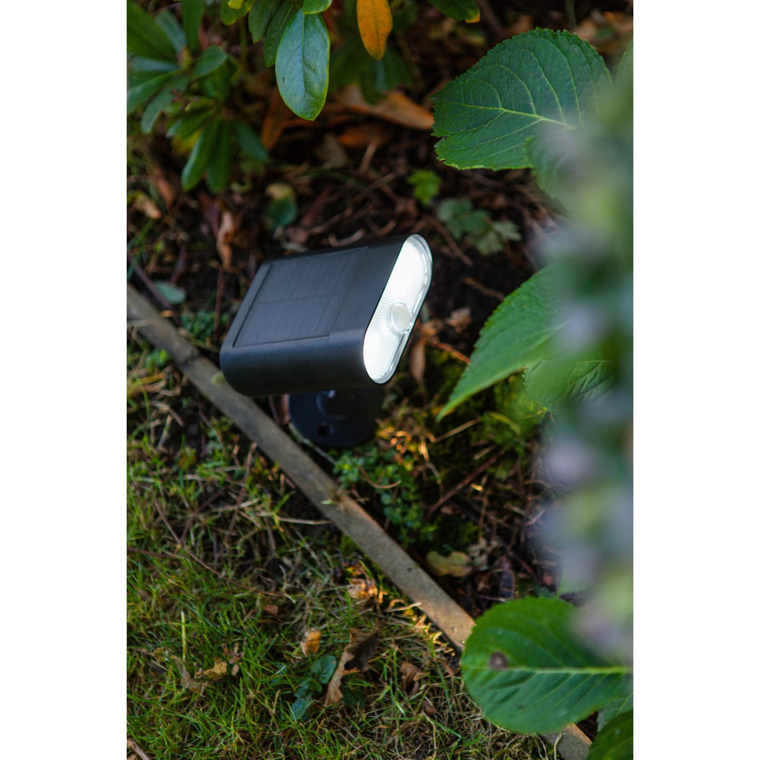 Schwarze Lutec LED Solar-Wandleuchte Ginbo, 500 lm, im Garten.