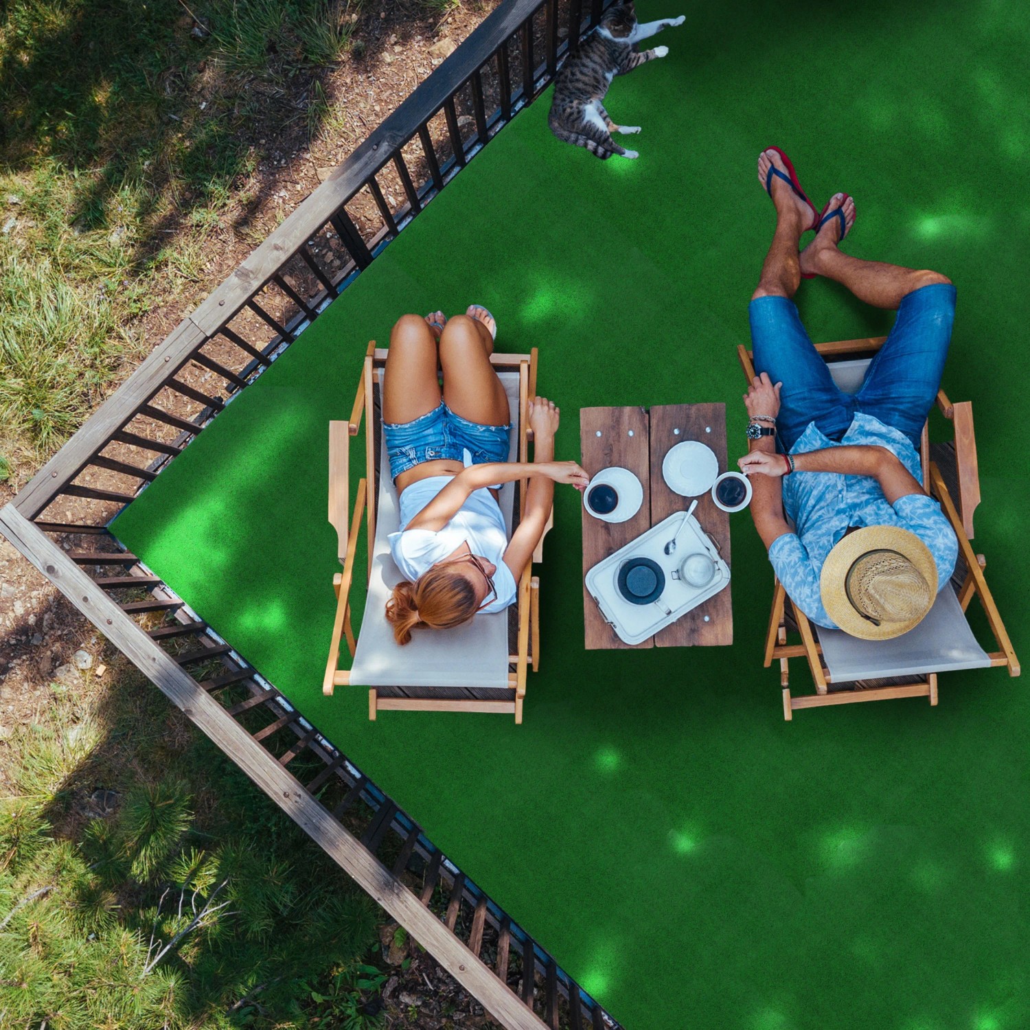 Heller Kunstrasen: Paar entspannt auf Rasenteppich Garden B1 hellgrün im Garten.
