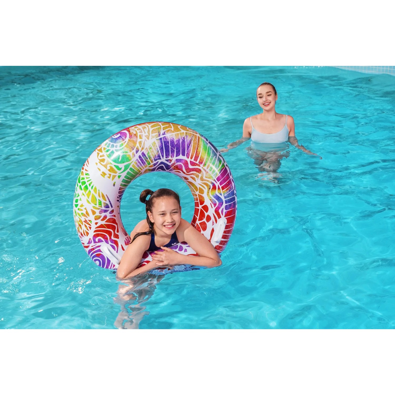 Mädchen schwimmt mit buntem Bestway Schwimmring Summer Swirl im Pool.