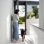Frau bedient Bosch Smart Home Fenster-/Türsensor II Plus Anthrazit an Terrassentür.