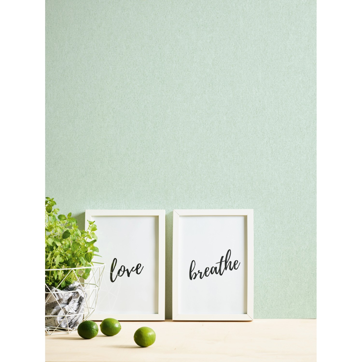 A.S. Création Vliestapete Uni Grün an Wand, kombiniert mit Deko-Elementen.