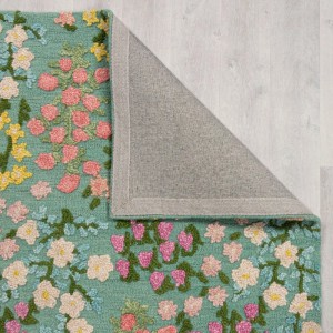 Flair Rugs Wollteppich Emilia Floral, mehrfarbiges Blumenmuster, Hoch-Tief-Struktur, 100% Wolle, Rückseite sichtbar auf Holz.